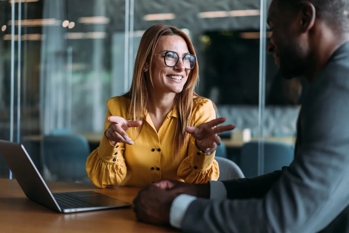 A lawyer in conversation with a client across a table.